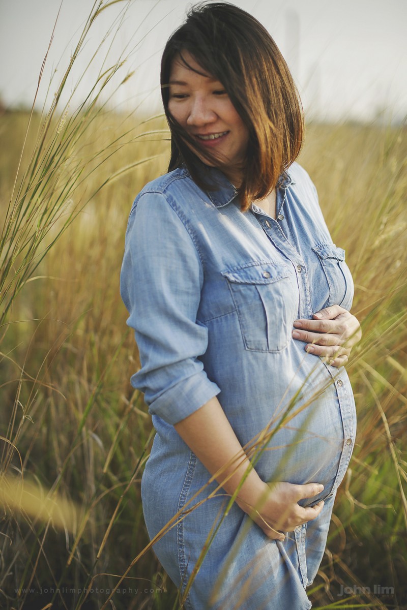 maternity photos of expecting mother, tall grass outdoors looking radiant and happy