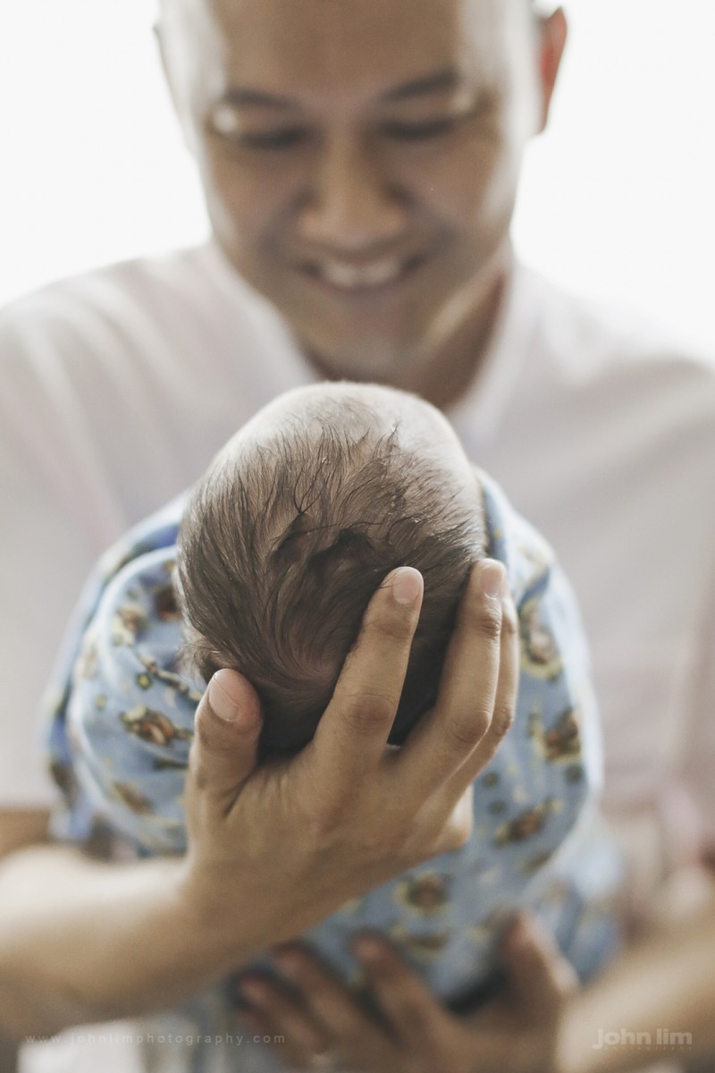 first day, first look at newborn baby at hospital, detail of baby's head, looked upon by father